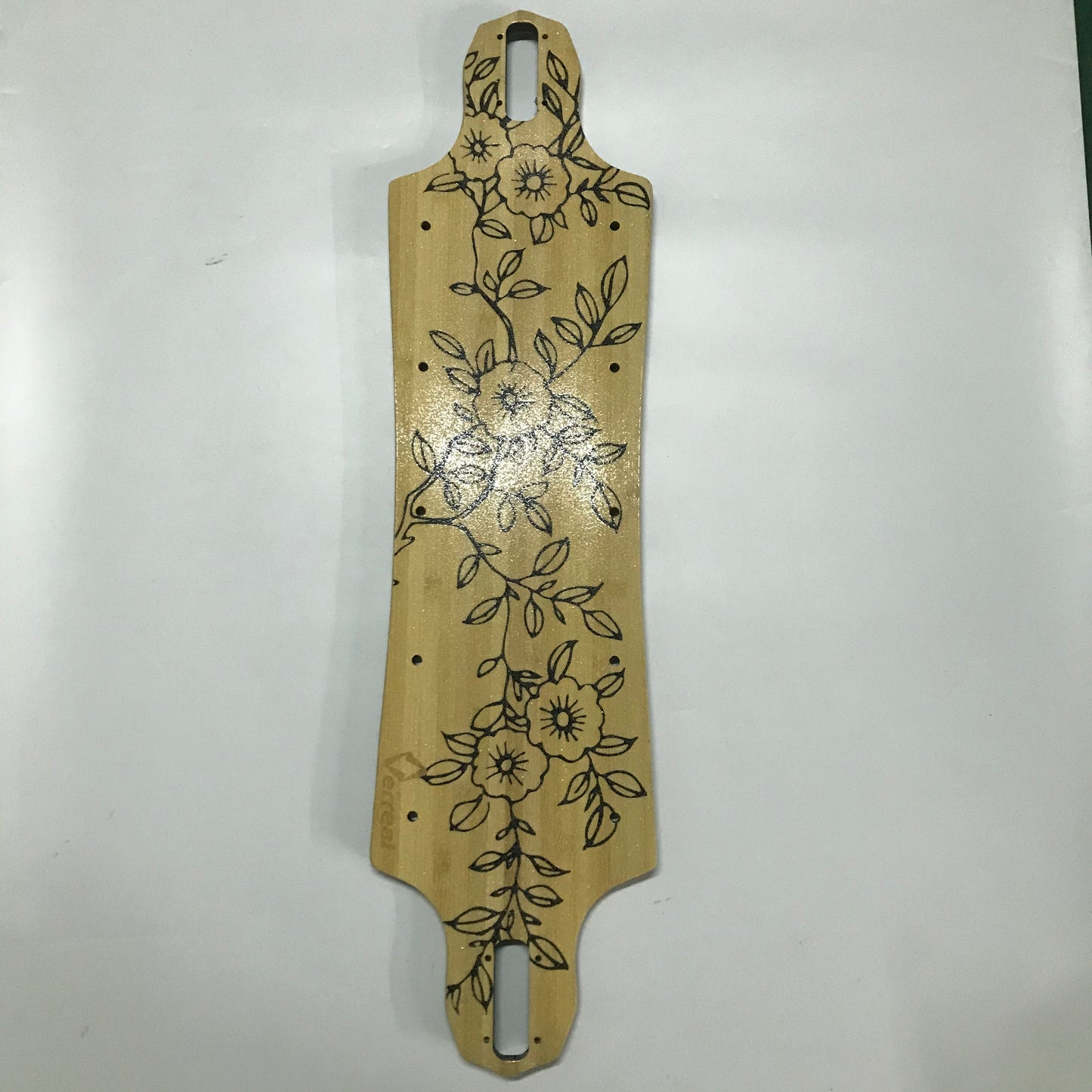 A beige Verreal RS skateboard deck with a floral pattern.